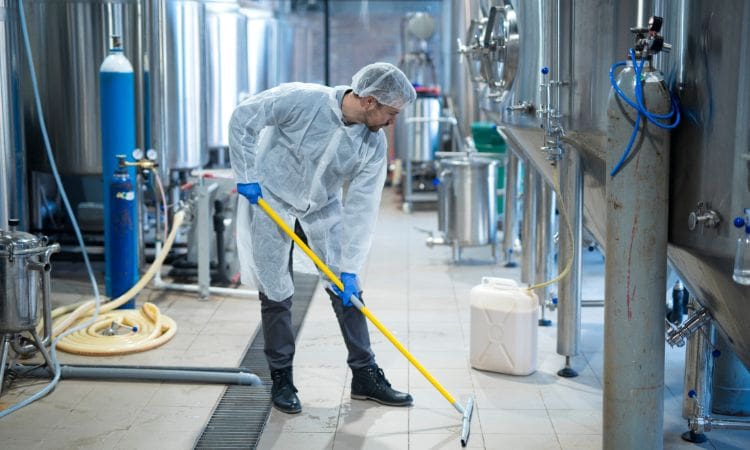 Person disinfecting an industrial floor - Unique cleaning Group